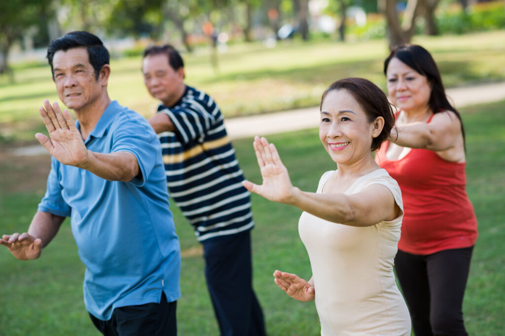Vietnamese senior people exercising together in the park. Tai Chi for Seniors