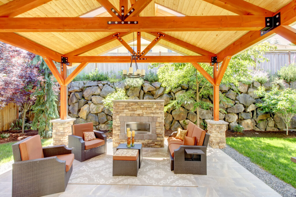 Exterior covered patio with fireplace and furniture. Wood ceiling with skylights. Patio Ready for Summer