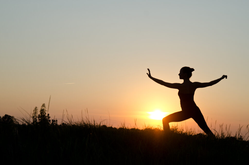 Woman praticing tai chi chuan at sunset. Benefits of Tai Chi