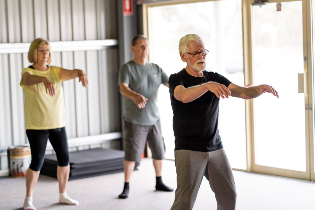 Group of seniors in Tai Chi class exercising in an active retirement lifestyle. Mental and physical health benefits of exercise and fitness in elderly people. Senior health care and wellbeing concept. Benefits of Tai Chi